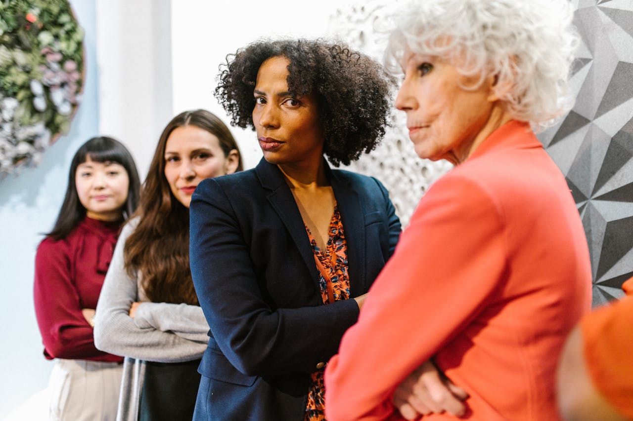 A diverse group of businesswomen confidently posing in a modern office setting.